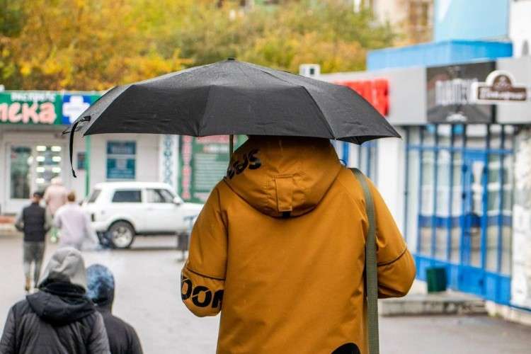 Человек с зонтом в осеннюю погоду