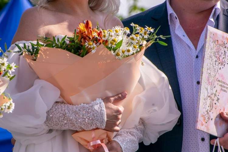 Жених и невеста со свидетельстом о заключении брака