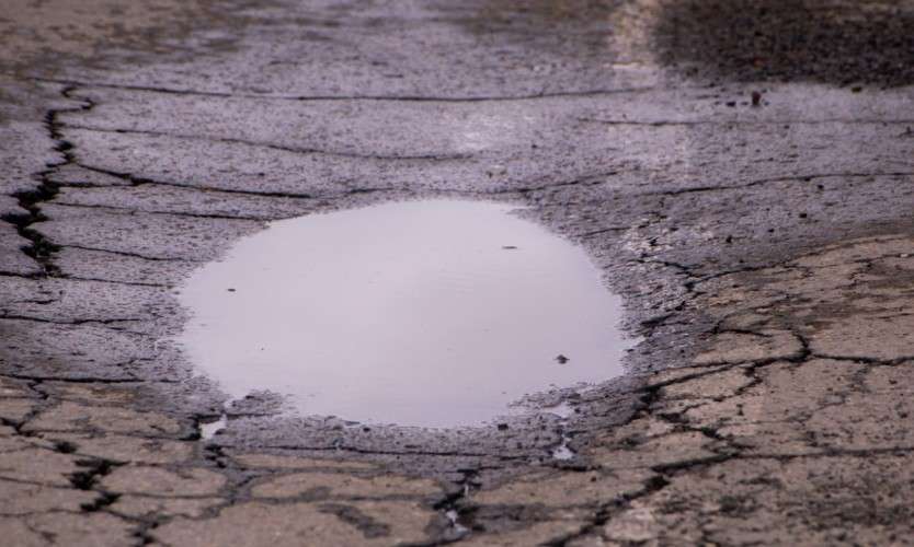 Лужа на потрескавшемся асфальте