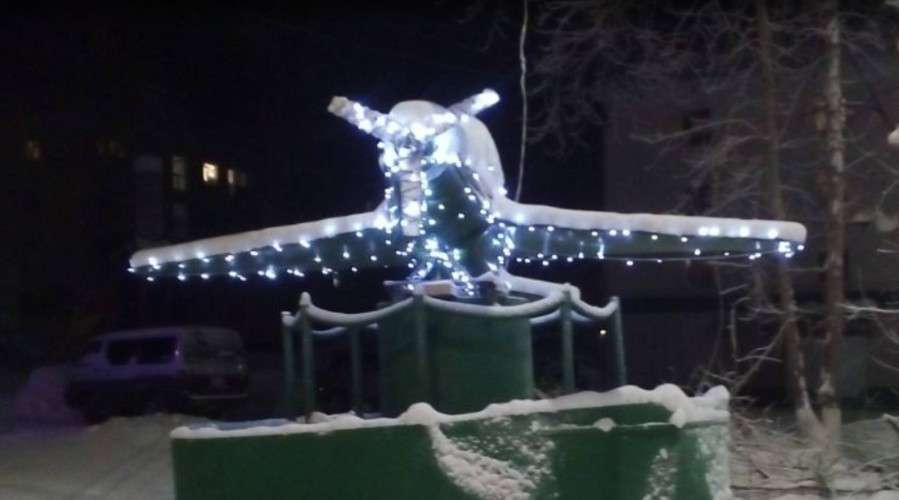 Макет самолёта, украшенный гирляндой