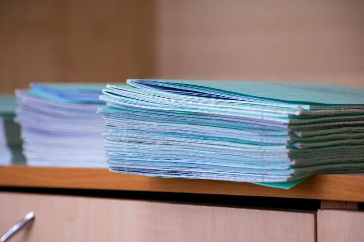 Стопка школьный тетрадей в клетку на столе