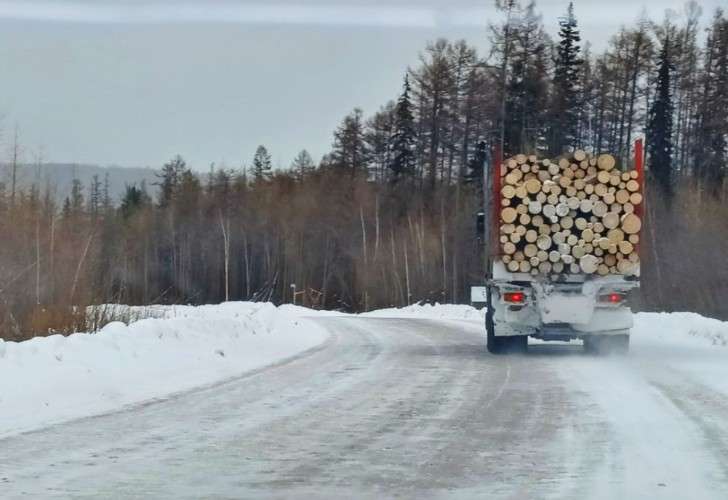 Лесовоз едет по дороге зимой