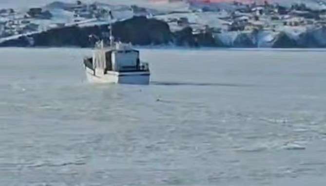 Замёрзший во льду катер