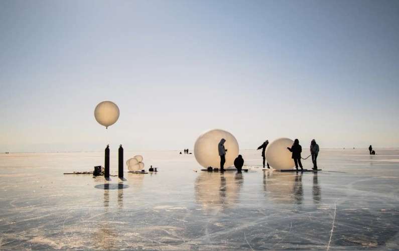 Участники фестиваля надувают гигантские шары на льду Байкала