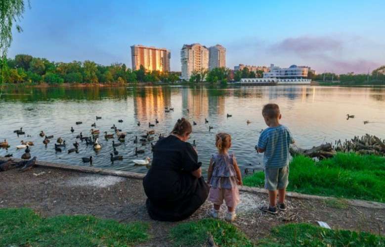 Семья на набережной кормит уток