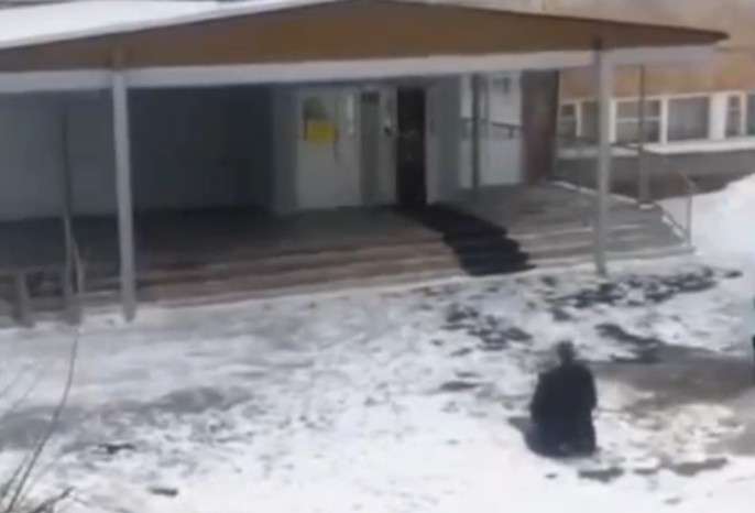 Мужчина на коленях перед школой