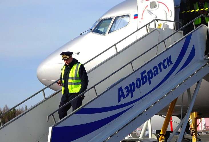 Спускающийся по трапу пилот в аэропорту Братска