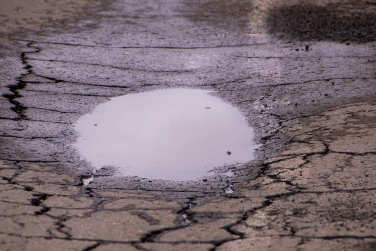 Лужа в яме на дороге