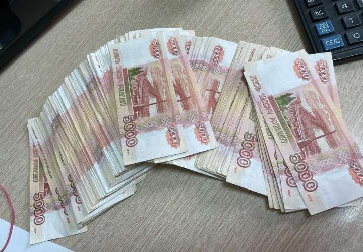 Банкноты на столе возле калькулятора