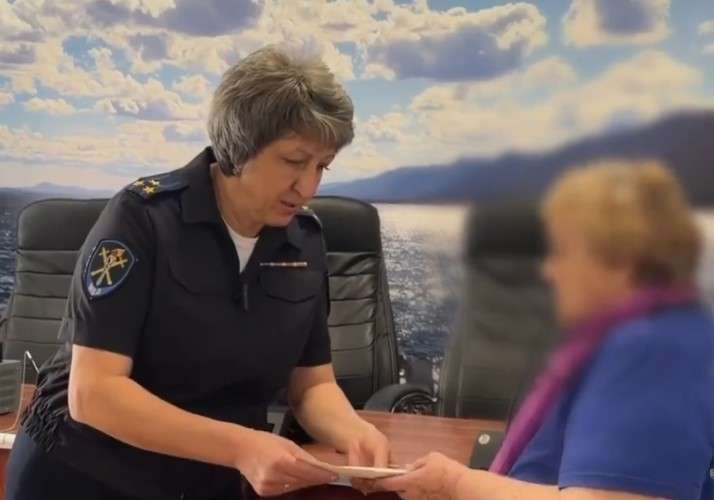 Сотрудник полиции передаёт денбги потерпевшей