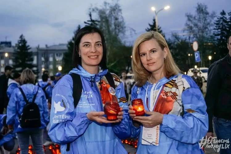 Девушки-волонтёры со свечами в руках