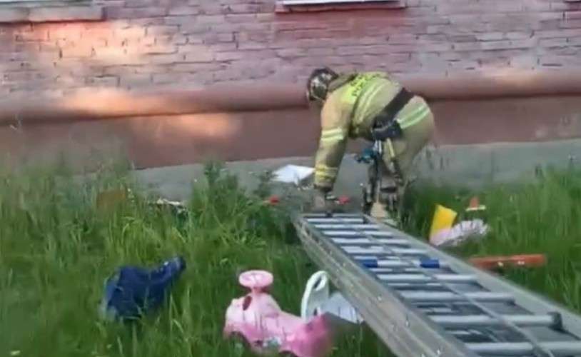 Спасатель с лестницей у стены дома