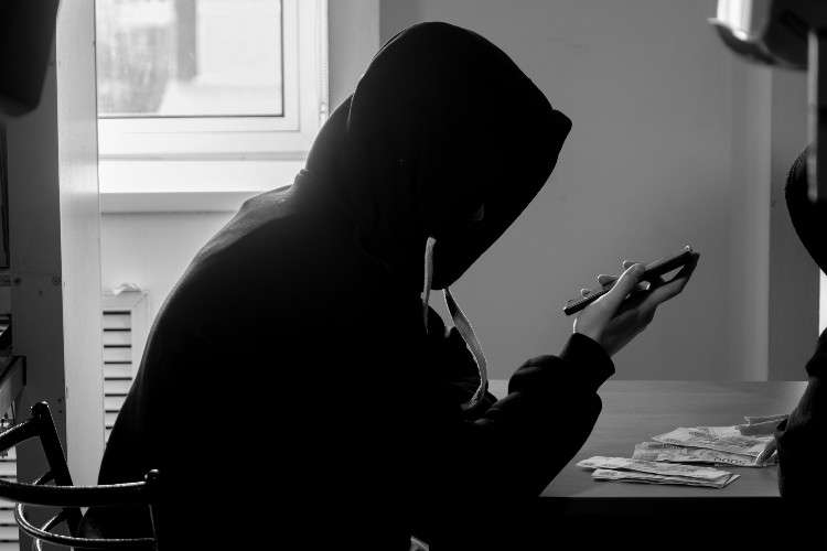 Человек в чёрной одежде с телефоном