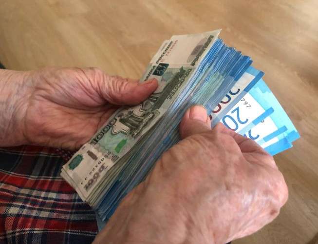 Деньги в руках у пожалой женщины