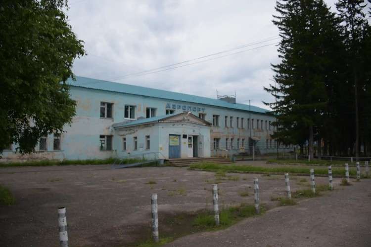 голубое здание старое двухэтажное с потёртостями и осыпавшейся краской, на нём надпись аэропорт