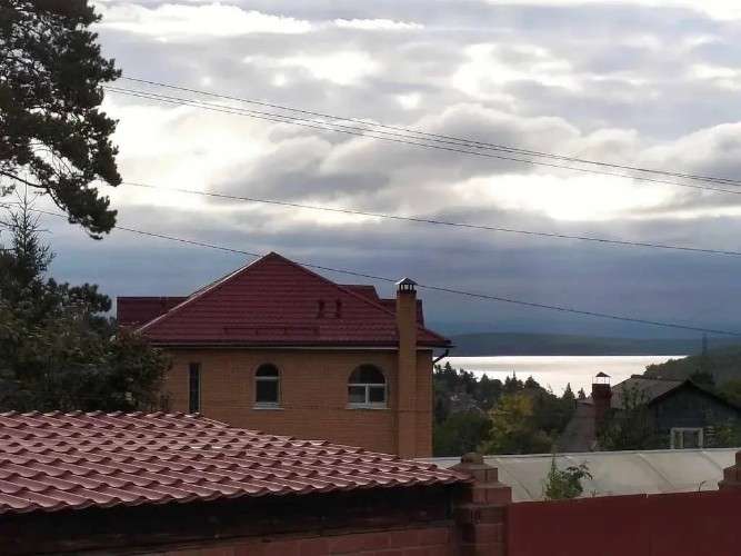 Дома, крыша, небо и линии электропередач.