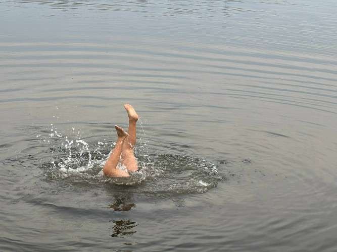 Подросток ныряет в водоем