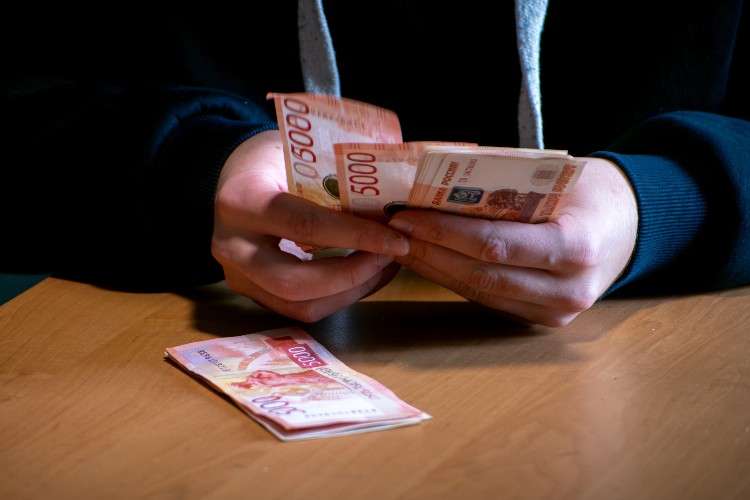 Мошенник пересчитывает деньги