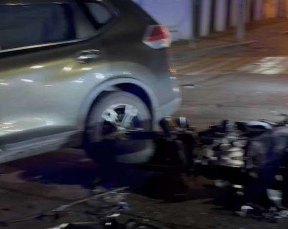 Авария. Мотоцикл лежит рядом с автомобилем, в который врезался.