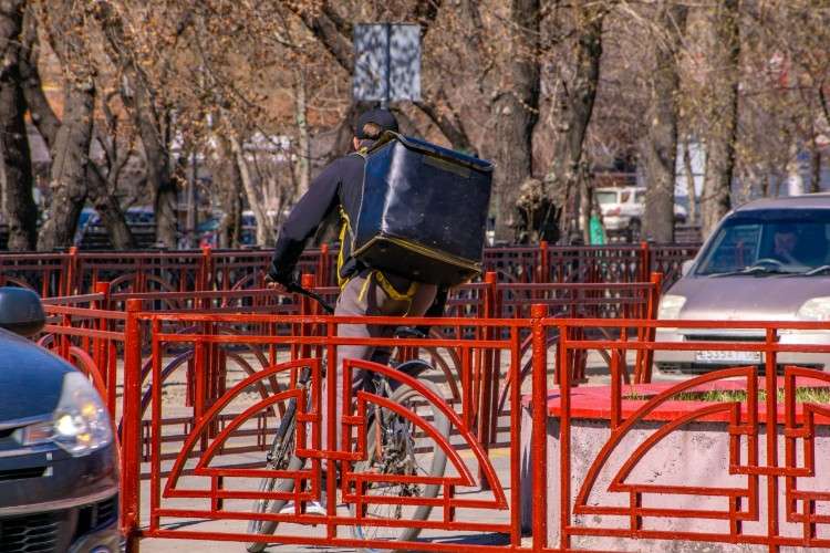 Курьер едет на велосипеде.