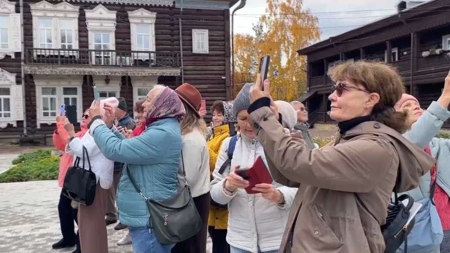 Пенсионеры с телефонами фотографируют объект за кадром