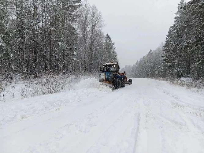 Трактор убирает снег