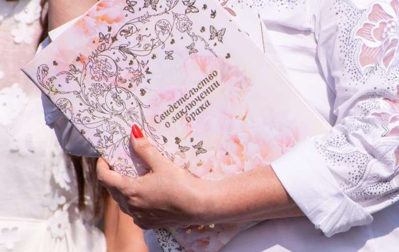 Свидетельство о заключении брака в женской руке