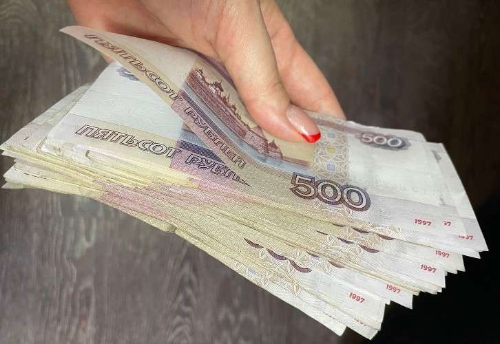 женщина держит денежные купюры в руке