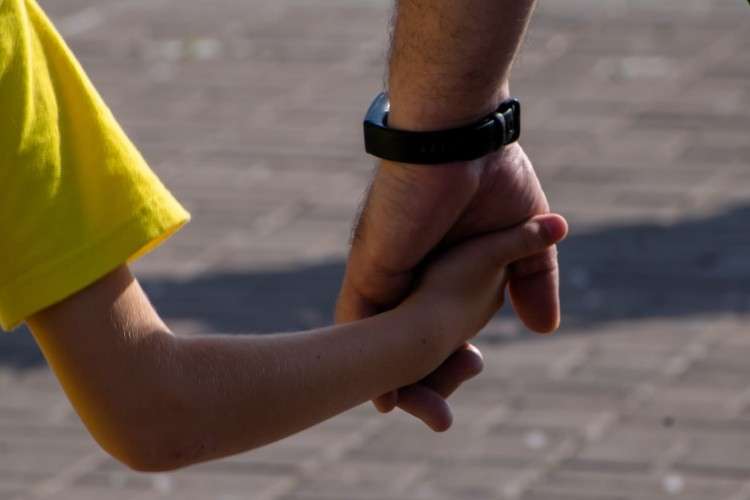 Ребенок и взрослый держатся за руки