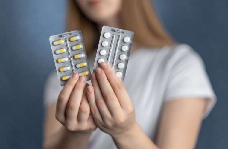 Девушка держит в руках упаковки с лекарствами