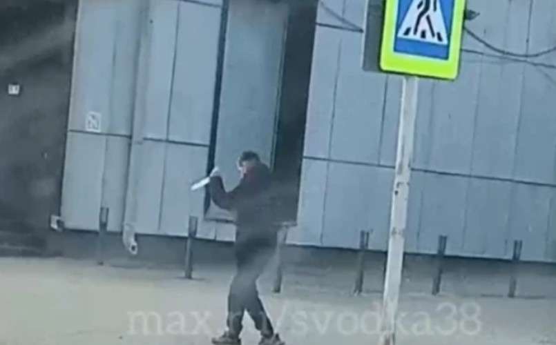 Человек стоит на улице с ножом в ркуах