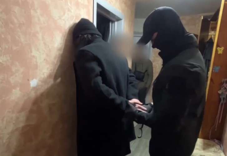 Оперативник надевает наручники на подозреваемого