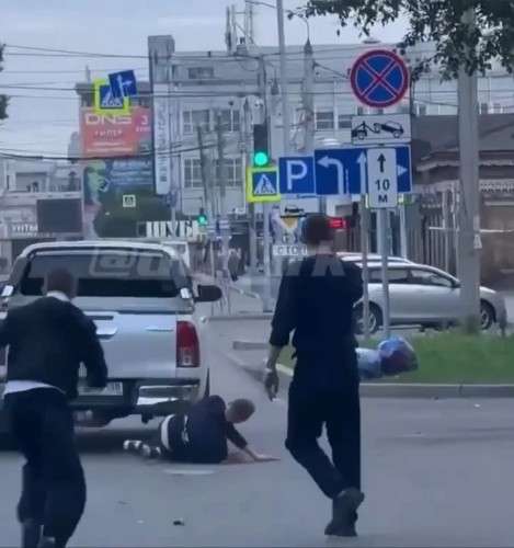 Мужчина лежит на земле после того, как его сбили. Машина проехалась по нему.