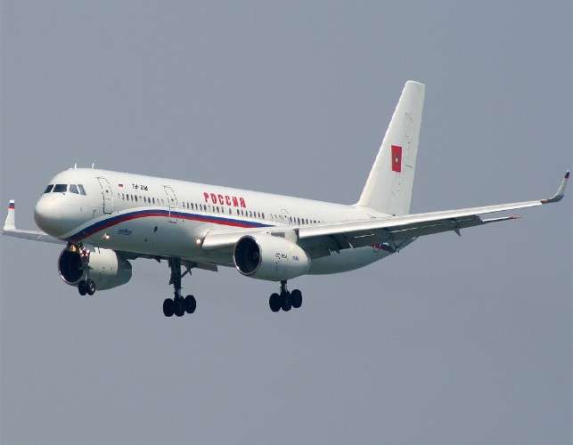 Самолёт Ту-214 белого цвета с красной надписью "Россия" на борту и флагом России на ливрее