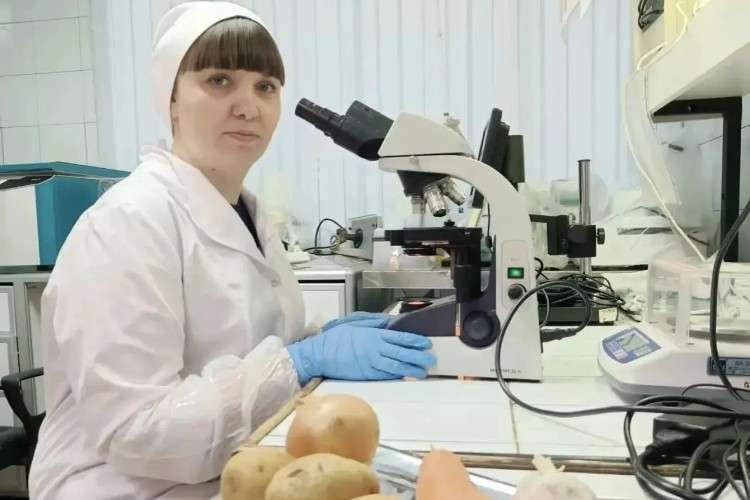 Специалист с микроскопом проверяет продукты.