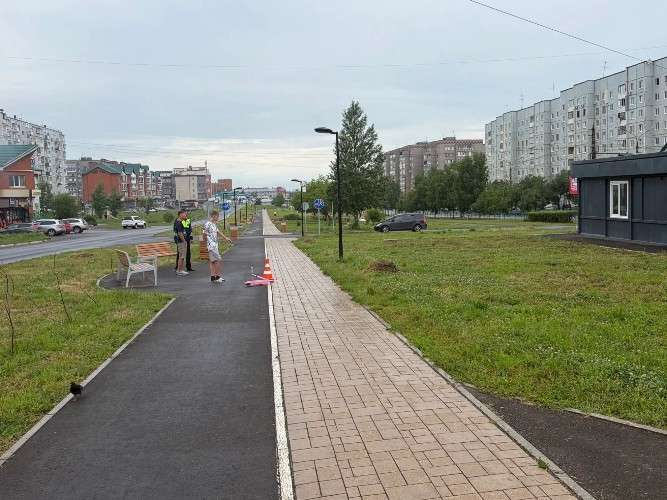 Розовый самокат лежит на велодорожке. Рядом стоят двое парней и сотрудник ГИБДД