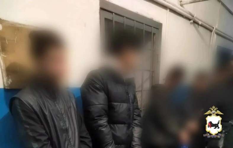 Иностранцы стоят в отделе полиции.