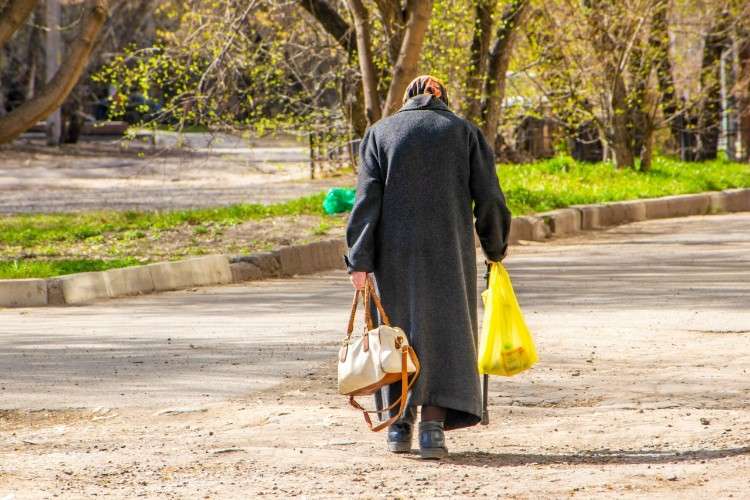 Пенсионерка с пакетами и сумкой