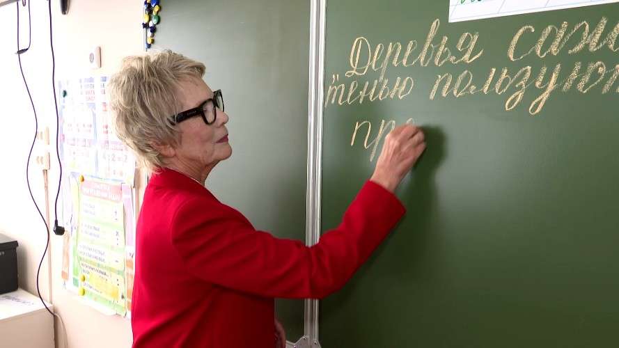 Учитель пишет на доске мелом