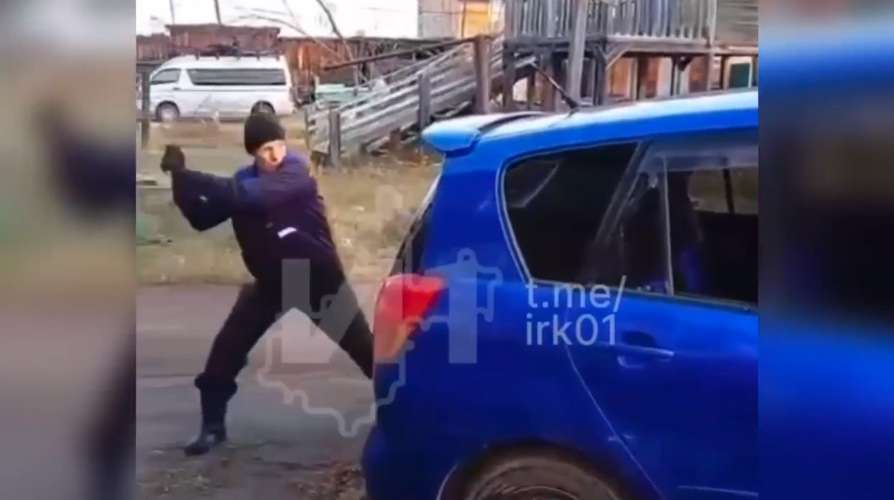 мужчина пытается ударить машину