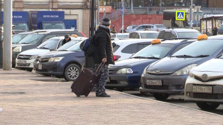 Турист с чемоданом на парковке у аэропорта
