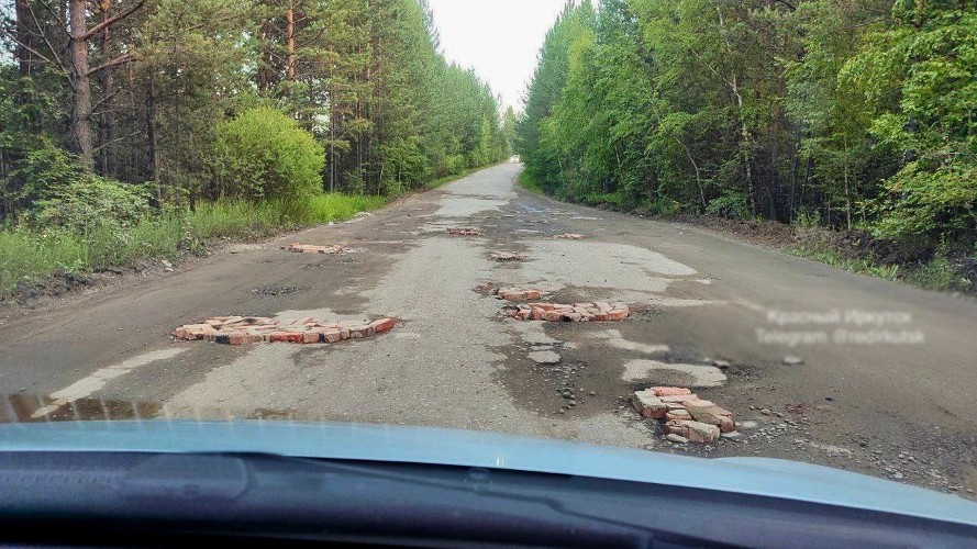 Кирпичом заделали ямы на дороге жители в Шелеховском районе